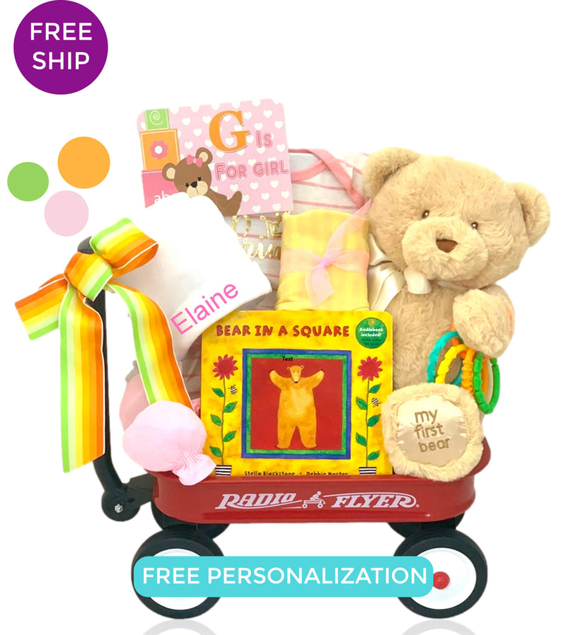 Classic mini wagon filed with book, plush teddy, personalized newborn hat and baby girl essentials.