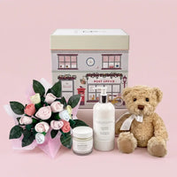 Luxury newborn gift box for baby girls with plush bear, bouquet, baby lotion, and cream — beautifully packaged and ready to give