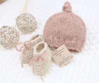 Handmade blush pink baby alpaca knotted cap and bootie set, flat lay, newborn size, soft natural fiber
