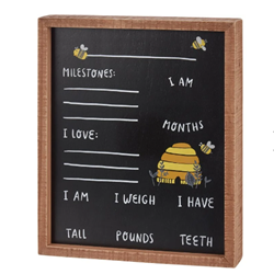 Bee-themed baby milestone board with wood frame, beehive and prompts for months, height, weight, teeth and milestones