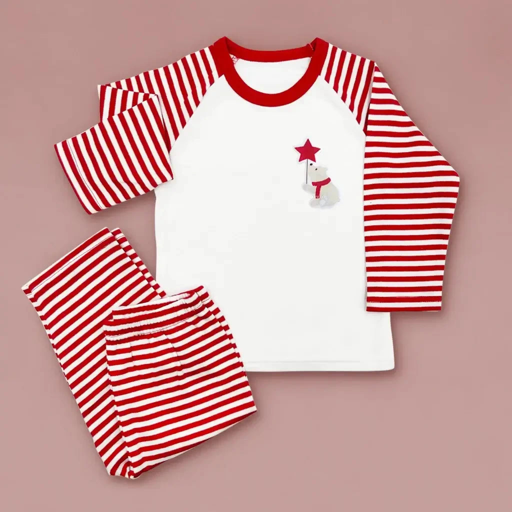 Close-up of the Christmas bear design on red and white striped baby pajamas