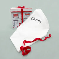White cotton swaddle blanket embroidered with a baby's name
Gift box: Christmas baby clothes bouquet in an illustrated gift box