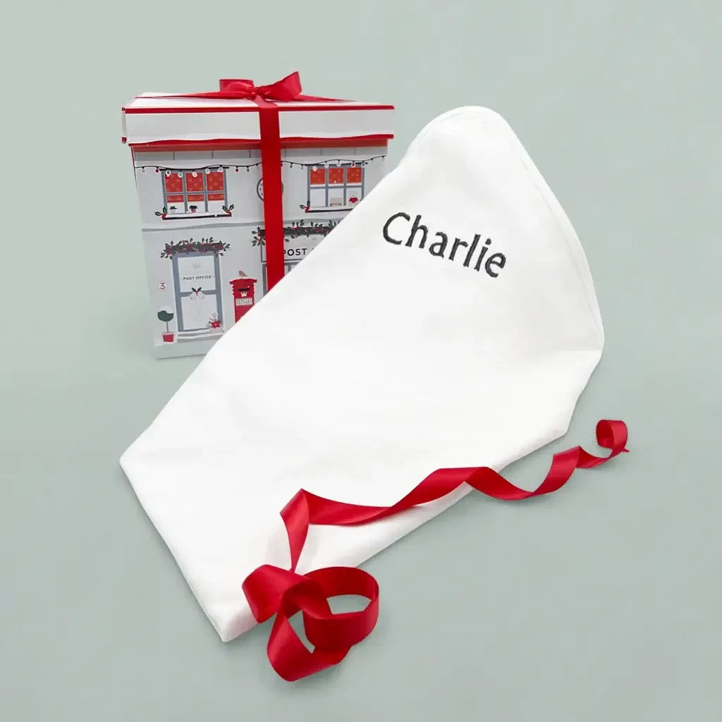 White cotton swaddle blanket embroidered with a baby's name
Gift box: Christmas baby clothes bouquet in an illustrated gift box