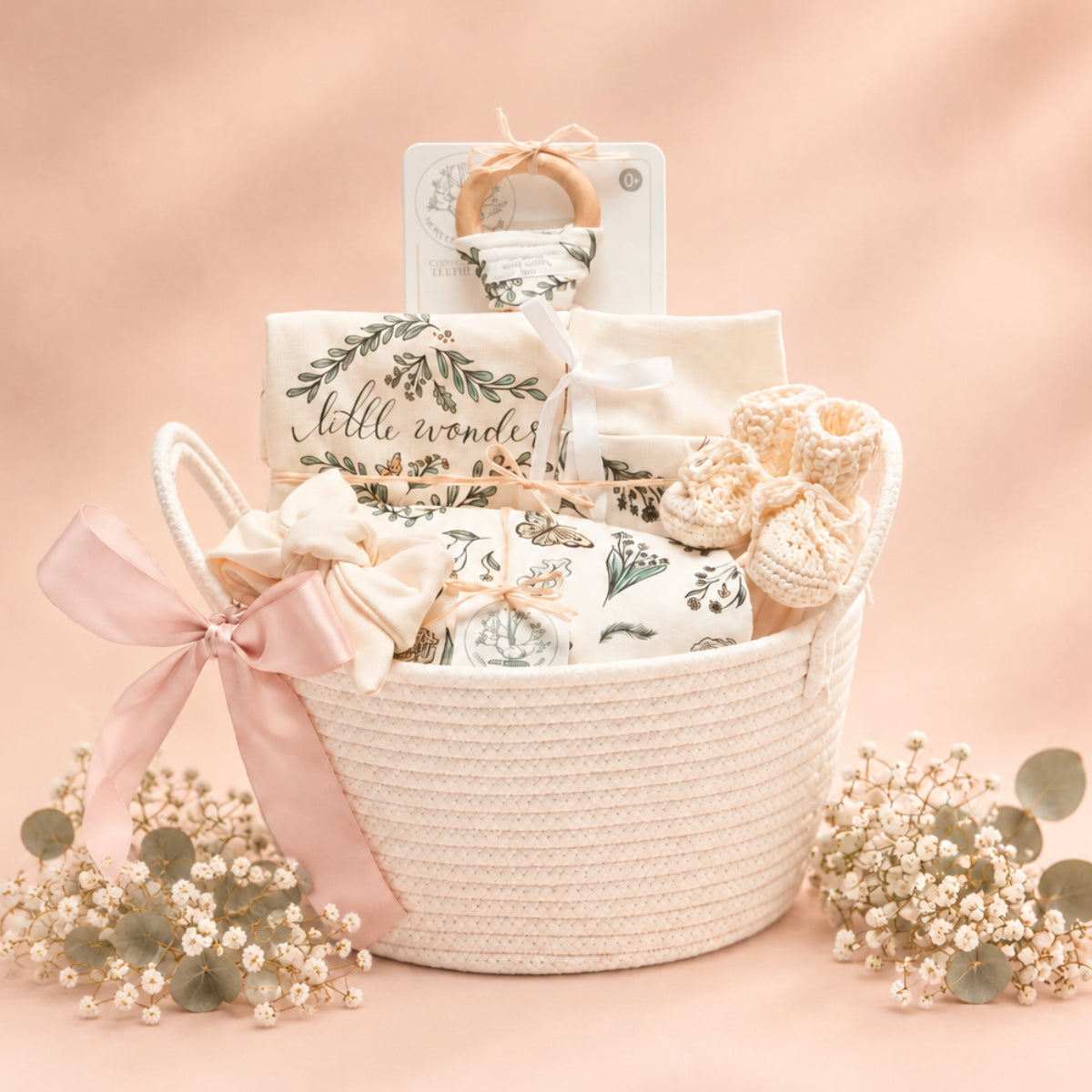 Garden Flutter baby girl organic gift set in a white rope basket with botanical wreath blanket, butterfly swaddle, knot hat and booties