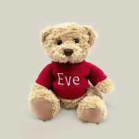Front of Christmas teddy bear with baby's name personalized on a red knitted sweater