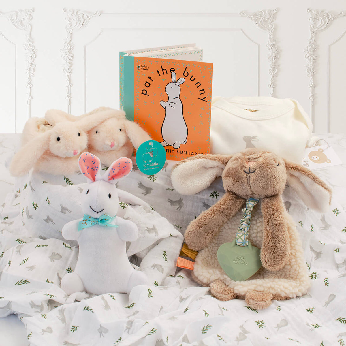 The Little Bunny Welcome Set with Pat the Bunny book, plush white bunny, organic cotton bodysuit, bunny slippers, lovey with teether, and muslin swaddle blanket