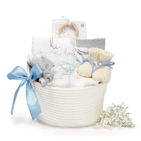 Nautical baby boy gift basket featuring baby blue and grey organic layette set with sailboat bodysuit, burp cloth, teether, and rope basket