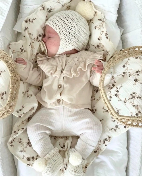 Newborn baby wearing handmade organic cotton acorn bonnet and pom pom booties, coming home outfit accessories