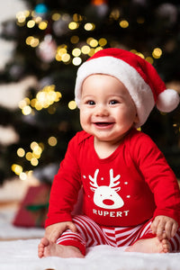 Baby boy wearing a personalized red Christmas reindeer t-shirt and Santa hat