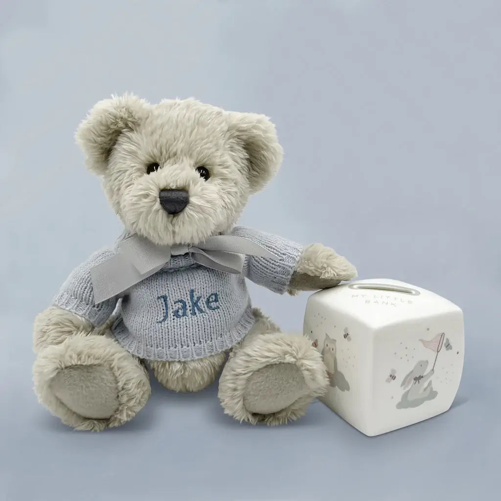 Personalized teddy bear in blue knitted jumper with bone china money box keepsake gift set for baby boys, presented in an illustrated gift box with satin ribbon
