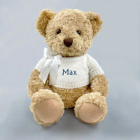 Personalized baby boy teddy bear keepsake gift in white knit sweater with blue embroidered name and white ribbon bow