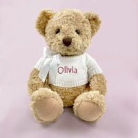 Personalized baby girl teddy bear in white knit sweater with pink embroidered name and white ribbon bow