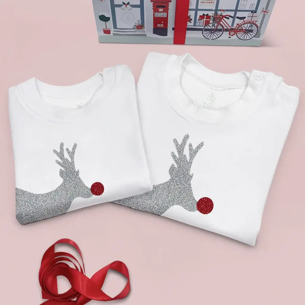 Close-up of sparkly reindeer design on white Christmas baby t-shirt