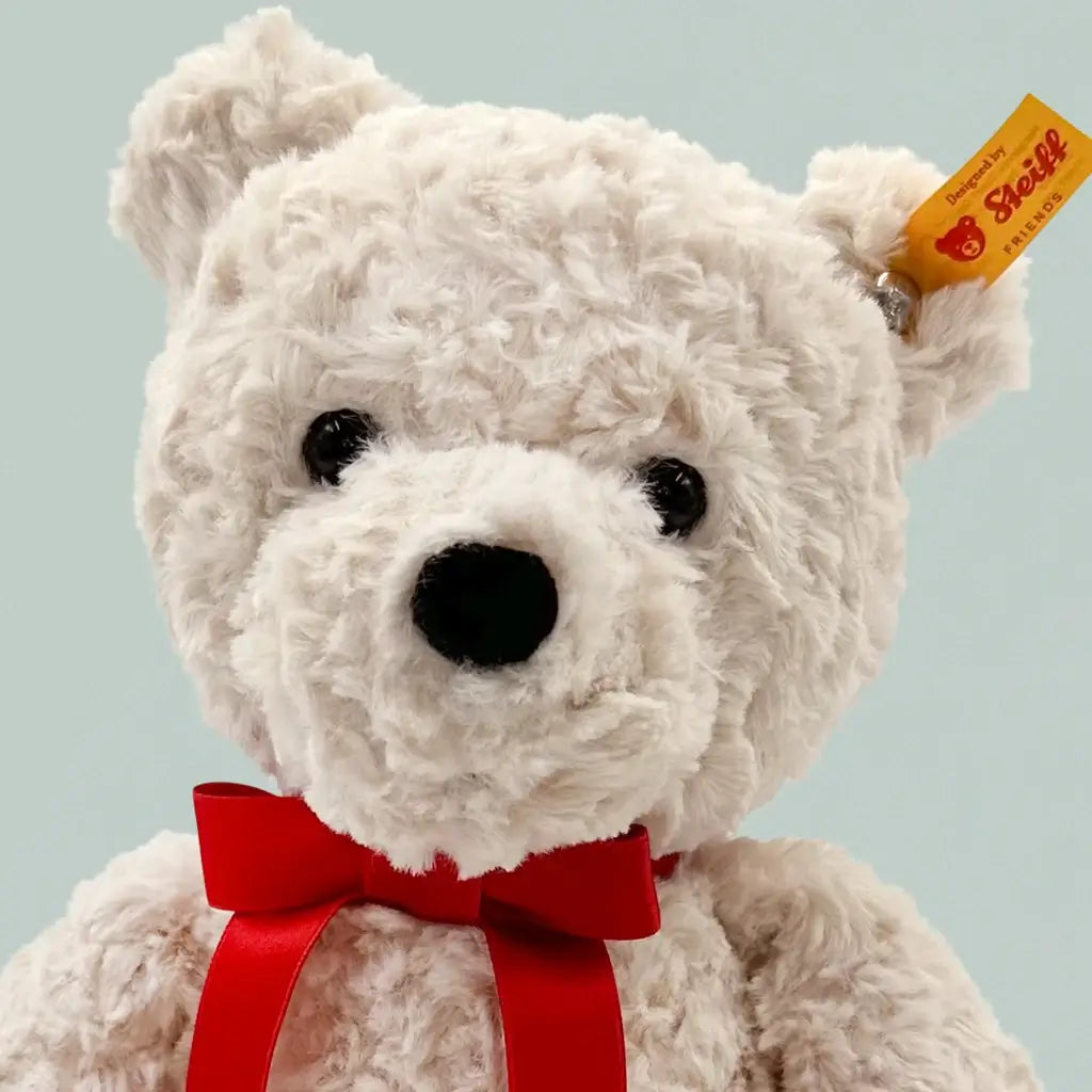 Close-up of Steiff yellow label and steel button in ear tag on white teddy bear