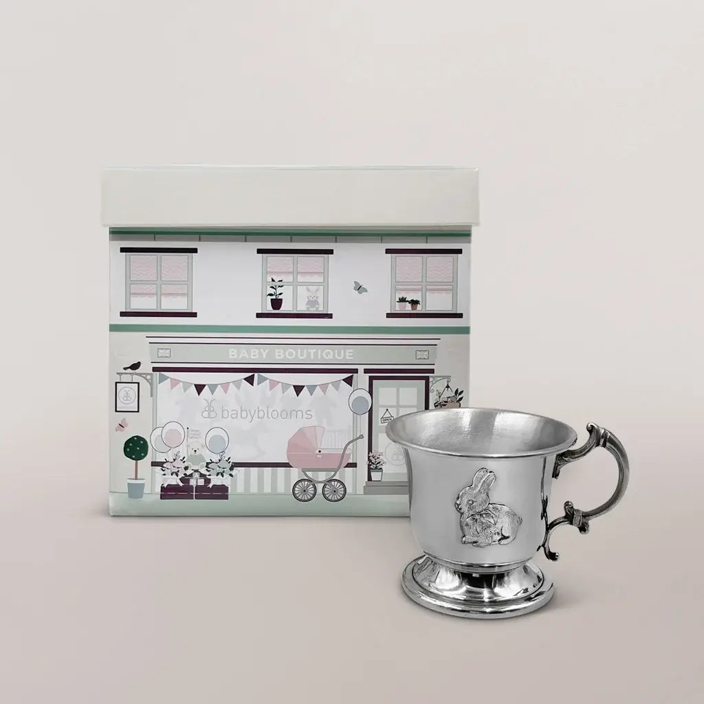 Handcrafted English pewter baby cup in Victorian pedestal style with ornate handle and detailed bunny motif, presented in an illustrated gift box